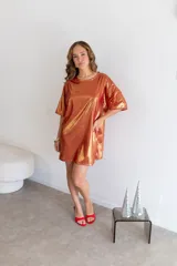 Remerón dorado con textura brillante y mangas cortas.