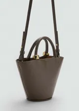 Bolso color verde oliva con forma trapezoidal, efecto piel, asa de mano y asa larga desmontable.