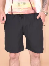 Short deportivo negro, de material ligero y secado rápido, con cintura elástica y cordón ajustable. Presenta bolsillos laterales con cierre.