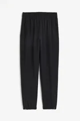 Pantalón de correr negro de tejido funcional DryMove™, corte estándar, cintura elástica con cordón, bolsillos laterales con cierre oculto, piernas levemente ajustadas con elástico revestido y cierre en los bajos. Stretch en cuatro direcciones.