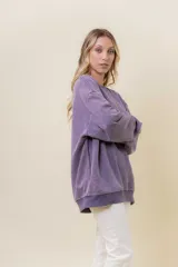 Sweater de mujer color lila con efecto lavado vintage, de calce oversize, cuello redondo y terminaciones acanaladas.