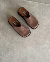 Sueco en cuero vacuno color marrón con suela negra, de diseño minimalista y cómodo.