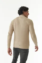 Sweater básico color beige de punto acanalado, con medio cierre frontal, cuello alto y logo bordado en el pecho.