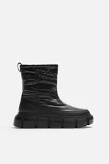 Bota corta color verde militar con diseño acolchado, tirador trasero y suela track negra.