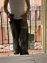 Pantalón de jean gris oscuro con corte amplio y estampado con el logo de la marca en la pierna izquierda.