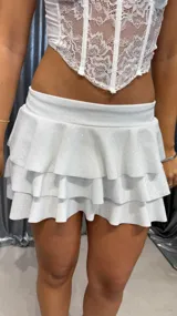 Minifalda blanca con textura brillante y tres volados.
