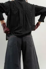 Pantalón de jean azul de pierna ancha y tiro medio, con cinco bolsillos y pespuntes a contratono.