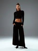 Top negro con cuello alto, mangas largas de tul y corte crop.