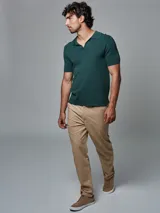 Pantalón color beige de corte regular fit, confeccionado en lino. Cuenta con dos bolsillos frontales y dos bolsillos posteriores, bajo con botamanga y presilla, aplique de badana.