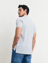 Chomba celeste con estampado de lunares blancos, cuello clásico y mangas cortas.