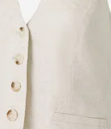 Chaleco color crudo confeccionado en viscolino, con escote halter, cierre frontal con botones, bolsillos delanteros falsos y bajo en V.