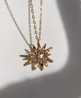 Collar con cadena fina negra y dije de estrella plateada con incrustaciones de strass.