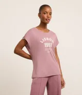 Remera deportiva de modal color lila con cuello redondo y mangas cortas. Estampa frontal con la leyenda "Lisbon 1991. Live like your life depends on it. Europe".