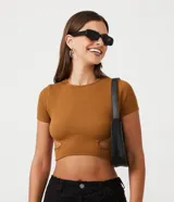 Top corto de manga corta, color marrón caramelo, con textura acanalada y aberturas tipo cutout a los costados de la cintura.