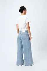 Pantalón jean de calce ultra wide con pierna extra ancha y ruedo desflecado, de tiro medio y construcción clásica en denim.