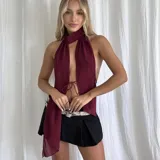 Top color borgoña con cuello halter y lazo ajustable en el frente.