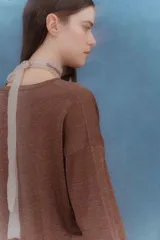 Sweater color beige de tejido de punto con brillo, escote en V y mangas largas.