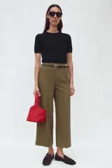 Pantalón culotte color verde oliva, de tiro medio y pierna ancha. Incluye cinturón ajustable con hebilla metálica y cierre lateral con cremallera oculta.