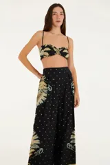 Pantalón recto de viscosa con estampado floral en tonos beige y celeste sobre fondo negro. Tiene cintura alta y corte clásico.