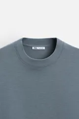 Sudadera negra de corte relaxed fit, confeccionada en tejido interlock de algodón con elasticidad. Tiene cuello redondo, manga corta y bajo acabado en rib.