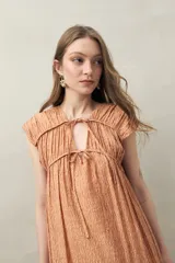 Vestido largo con estampado floral celeste y blanco, escote ajustable con lazo y frunce en la parte superior.