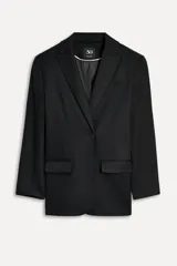 Blazer negra oversize de algodón con cuello solapa con muesca, manga larga con hombreras y hombro caído, bolsillos con solapa en delantero y de vivo en pecho, detalle de solapa en interior, forro interior y cierre frontal con botones.