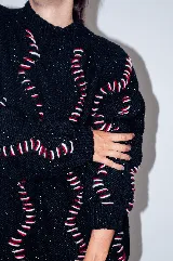 Buzo tejido a mano con lana merino color negro con bordado de ochos en blanco y rojo.