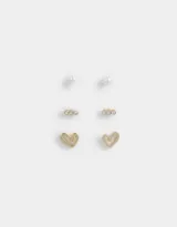 Set de tres pares de aros dorados con cierre de tope a presión: un par de aros pasantes de perla, un par con strass y un par con forma de corazón.