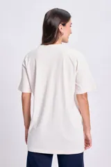 Remera de manga corta color crudo, corte oversize, con estampa de Río de Janeiro en color verde.