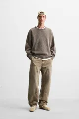 Sweater marrón de cuello redondo y manga larga, tejido con textura bouclé y efecto lavado.