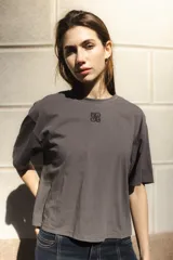 Remera negra de algodón con corte cuadrado, cuello redondo y logo bordado en color naranja.