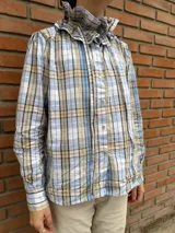 Camisa de algodón a cuadros celestes, beige y marrones, con cuello victoriano con volados y botones de nácar.