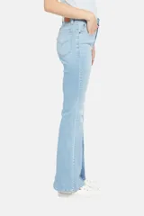 Pantalón de jean celeste con corte flare y diseño de parches en diferentes tonos de azul.