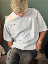 Remera color crema de corte holgado con estampado en la espalda que dice "Ittai Stars" en letras cursivas, "AN IBIZA PRODUCE" en mayúsculas y "Ittai Stars Department Gallery - Ibiza Edition" en letras pequeñas.