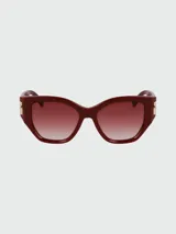 Lentes de sol Longchamp color borgoña con lentes degradadas y apliques dorados en las patillas.