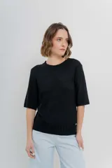 Buzo de punto liviano color negro, de diseño oversize con cuello redondo y mangas 3/4. Presenta terminaciones acanaladas en cuello, puños y cintura.