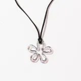 Collar con dije de vidrio transparente en forma de flor de cinco pétalos y cordón negro.