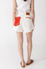 Short de denim de calce amplio y tiro alto, con ruedo desflecado y detalles de crochet en el borde de los bolsillos frontales.