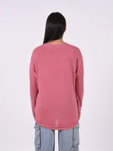 Blusa de tejido de punto color rosa viejo, con cuello redondo y mangas largas. Presenta apliques de strass en los hombros.