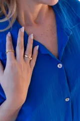 Vestido camisero de muselina color negro, de largo midi, con cuello clásico, manga corta y cierre frontal con botones.