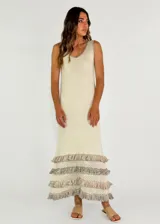 Vestido largo color beige, sin mangas, con escote en V y tres volados de encaje calado en el ruedo.