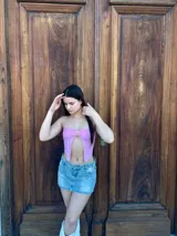 Top bandeau rosado con detalle de abertura en el centro y accesorio dorado.