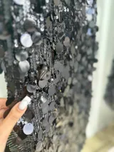 Vestido corto negro con lentejuelas de distintos tamaños, tirantes finos elastizados y cierre en la espalda.
