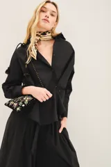 Camisa negra amplia de poplin con botones laterales para abotonar de forma cruzada.