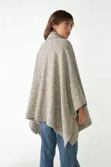 Capa con cuello, cierre frontal con botones y bolsillos delanteros. Confeccionada en lana fina sin teñir, diseñada exclusivamente por Don Baez.