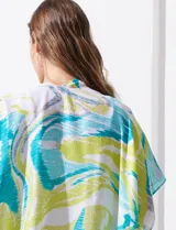 Kimono tejido con estampado abstracto en tonos azul, amarillo y blanco. Tiene mangas amplias estilo japonés y terminación de ruedo con borlas.