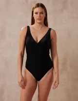 Malla enteriza negra de tejido texturizado, con escote en V cruzado, copa armada con sujetador interno y forro interno. Confeccionada en tejido italiano.