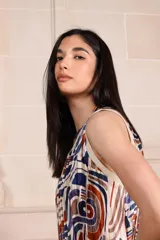 Vestido midi plisado con estampado de hojas en tonos marrones y ribete blanco en cuello y sisas.