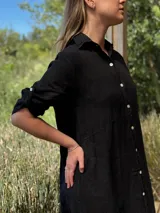 Vestido camisero largo de lino blanco, con corte en la cintura, abertura lateral y botones de nácar.