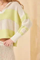 Sweater de punto a rayas horizontales color crema y azul marino, con cuello polo blanco y mangas largas. Tejido de algodón calado.